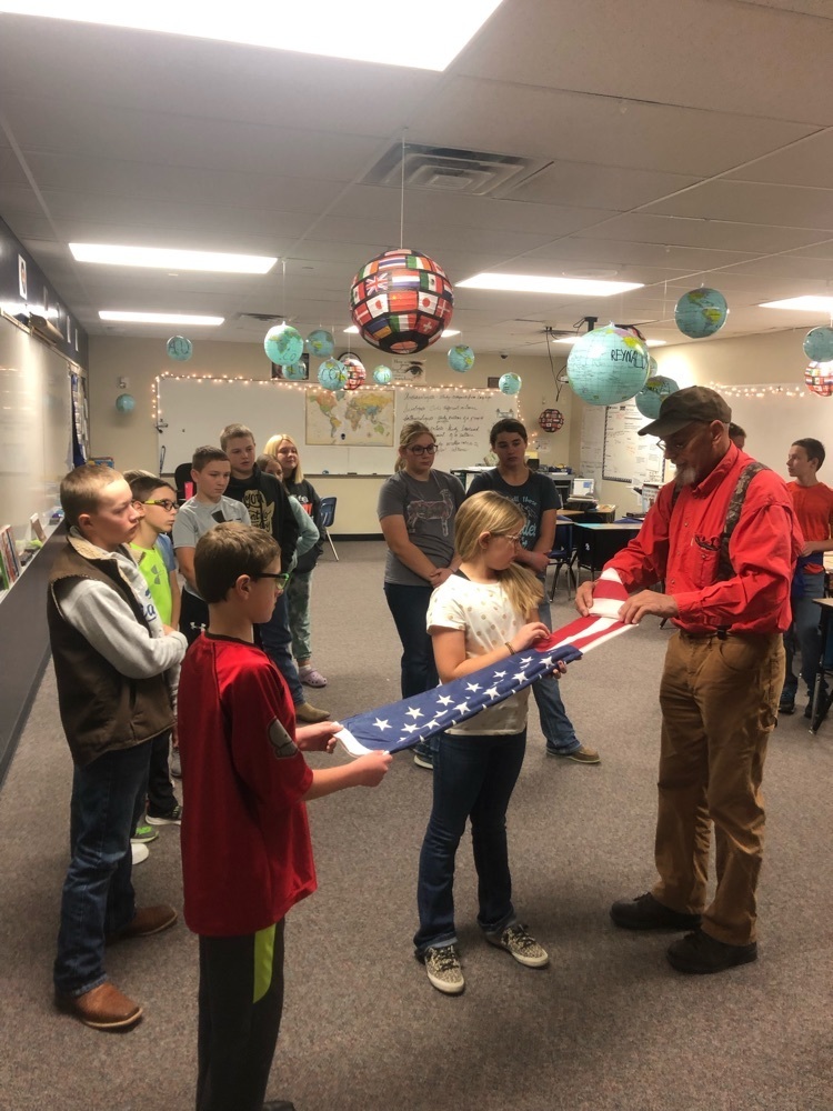 Lynn Swanson from VFW post 213 showing the 6th grade how to properly fold a flag for the Flag Folding ceremony on Veterans Day.