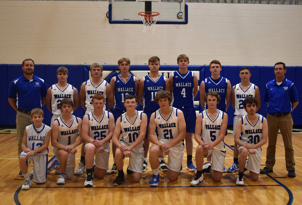 Boys basketball team pose on basketball court